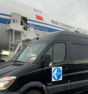 a black van parked in front of an airplane