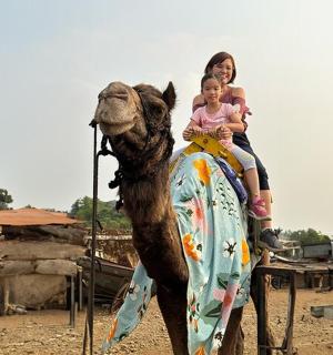 žena a dítě jedoucí na velbloudovi