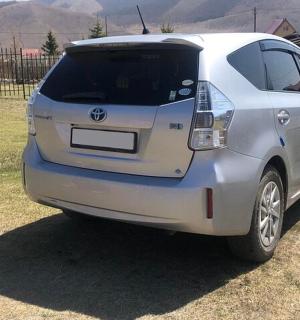 a white car parked in a field with mountains in the background