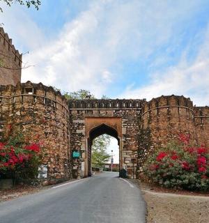 an old stone bridge with an archway on a road