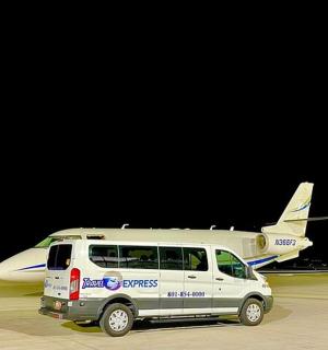 一辆白色货车停在一架小型飞机旁边