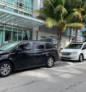 two cars parked in front of a building with palm trees