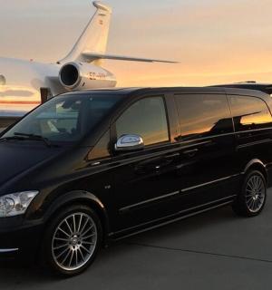two black vans parked next to an airplane