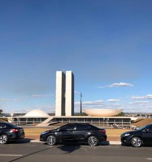 四辆汽车停在一栋建筑前的停车场