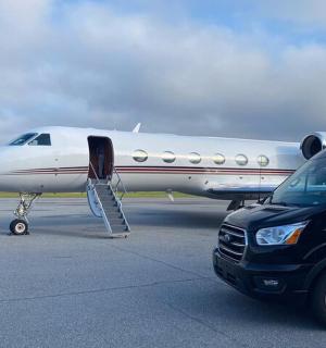 a car parked next to a plane on a runway