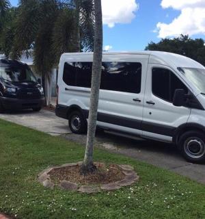 a white van is parked next to a palm tree