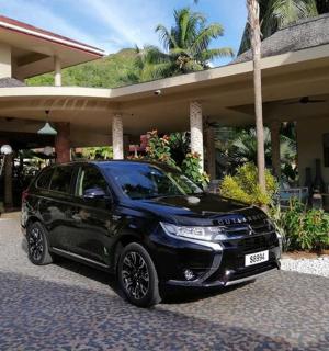 一辆黑色汽车停在一栋房子前面