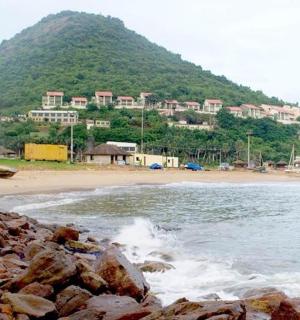 海滩上有岩石,背景是一座山