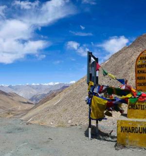 a sign on the side of a mountain with mountains in the background