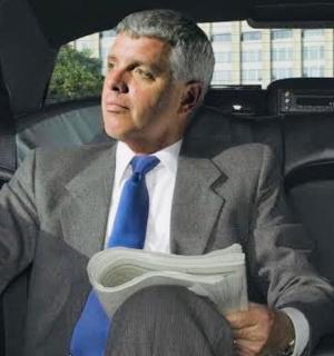 a man in a suit and blue tie sitting in a car