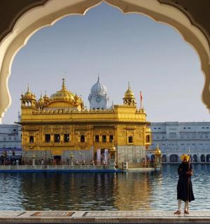 a woman standing in front of a golden temple