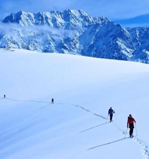 一群人从白雪皑皑的山上滑雪而下