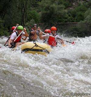 一群人坐在河里的木筏上