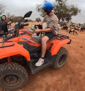 a group of people riding on an orange four wheeler
