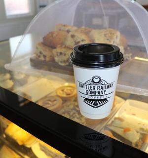 a cup of coffee sitting next to a bunch of donuts