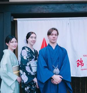 a group of three people standing in front of a banner