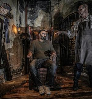 a painting of a man sitting in a chair next to two men