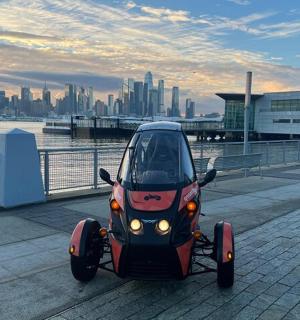 一辆停在水边人行道上的小汽车