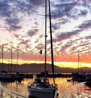 a group of boats docked in a marina at sunset