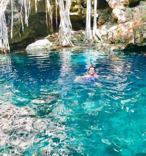 un home nedant en una piscina d'aigua blava
