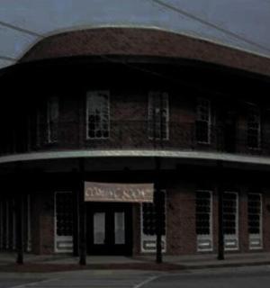 ein Backsteingebäude mit einem Schild davor