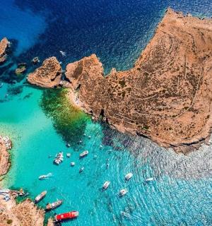 an aerial view of a beach with boats in the water