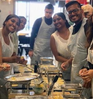 a group of people standing in a kitchen preparing food