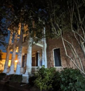 велика циглена зграда са белим стубовима ноћу