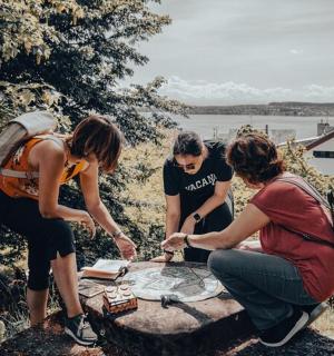 a group of people standing around a picnic table