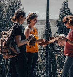 a group of three women standing on a fence