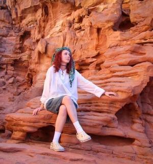 a woman sitting on a rock in a canyon