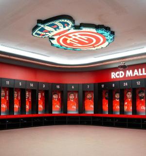 a arsenal dressing room with the arsenal logo on the wall