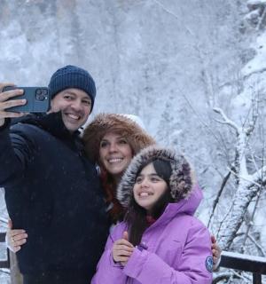 a man and two women taking a picture in the snow