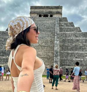 una dona dempeus davant d'una piràmide