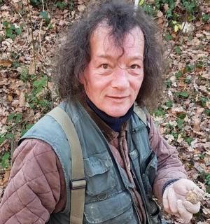 一个长发男子站在树林里