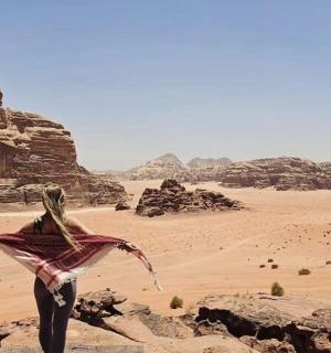 Žena stojí v poušti s drakem