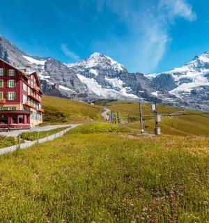 budova na kopci s horami v pozadí