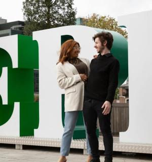 一名男子和一名女子站在一块大招牌前