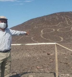 一名戴着面具的男子站在一座小山前