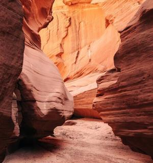 a slot canyon with a rock wall in the desert