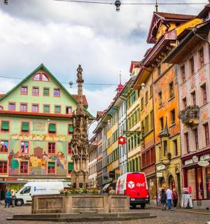 一条有许多建筑物和一辆红色巴士的城市街道