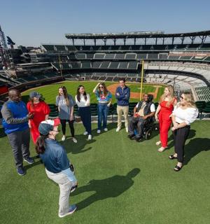 skupina lidí stojících na hřišti během baseballového zápasu