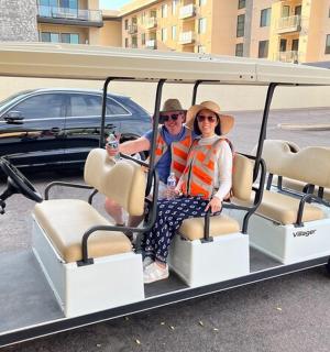 坐在高尔夫球车里的一男一女