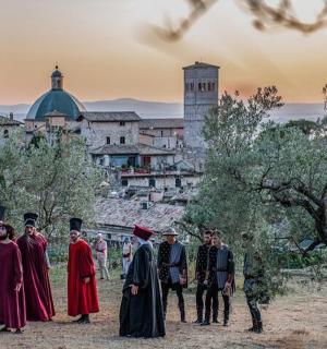 skupina lidí stojící před hradem