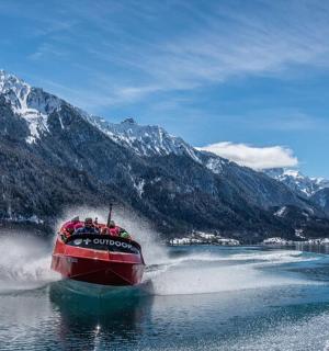 loď na jezeře se zasněženými horami