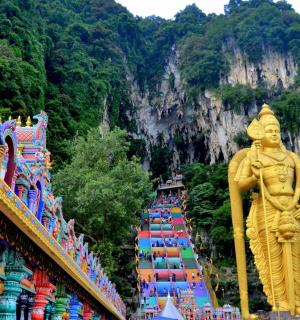 a large gold statue in front of a mountain