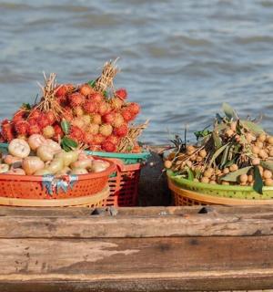 three baskets of fruits and vegetables on a boat