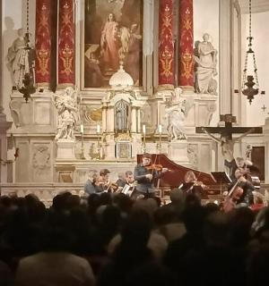 一群人坐在教堂里，旁边还有管弦乐队