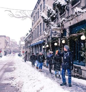a group of people walking down a snow covered street