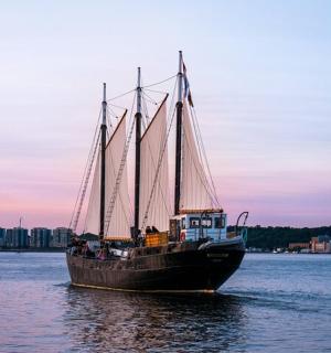 een boot met drie zeilen in het water